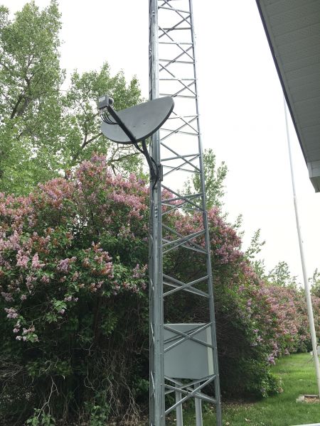 TV dish mounted near farm tower base.